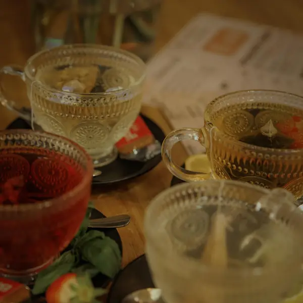 Two tall iced drinks in glass tumblers, one deep red, one over ice