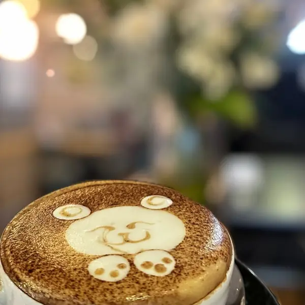 A latte with a pattern poured in the foam, seen from above on a wooden table