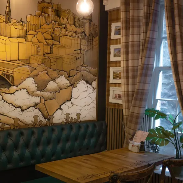 A green banquette against a stone wall, with a polished table in front of it