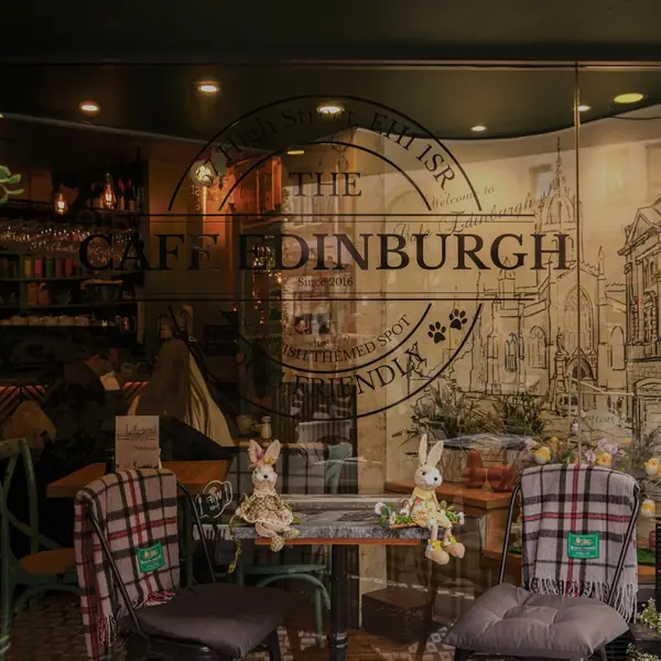 The word EDINBURGH in metal letters on a dark wall above plants and bench seating