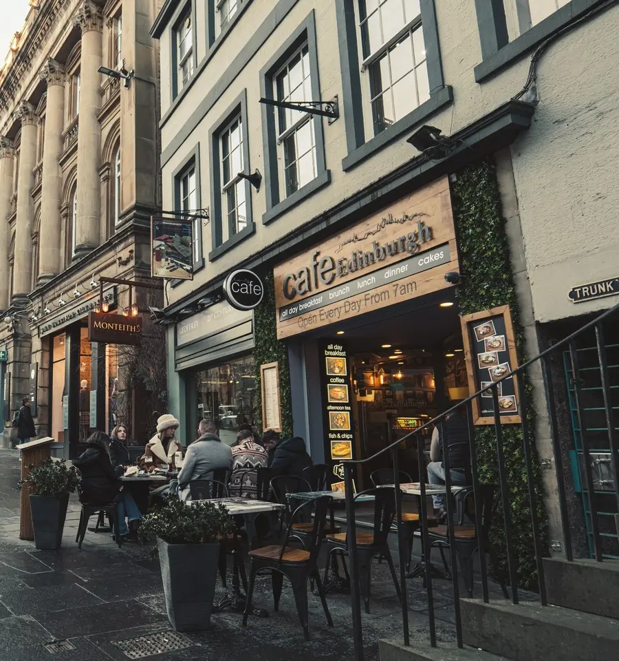 Tables and chairs set out on the pavement in front of the cafe on an overcast morning