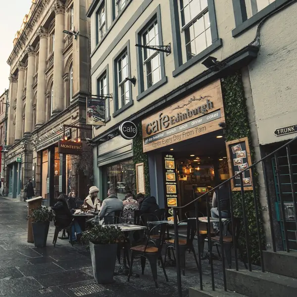 Tables and chairs on the pavement in front of the cafe on an overcast day